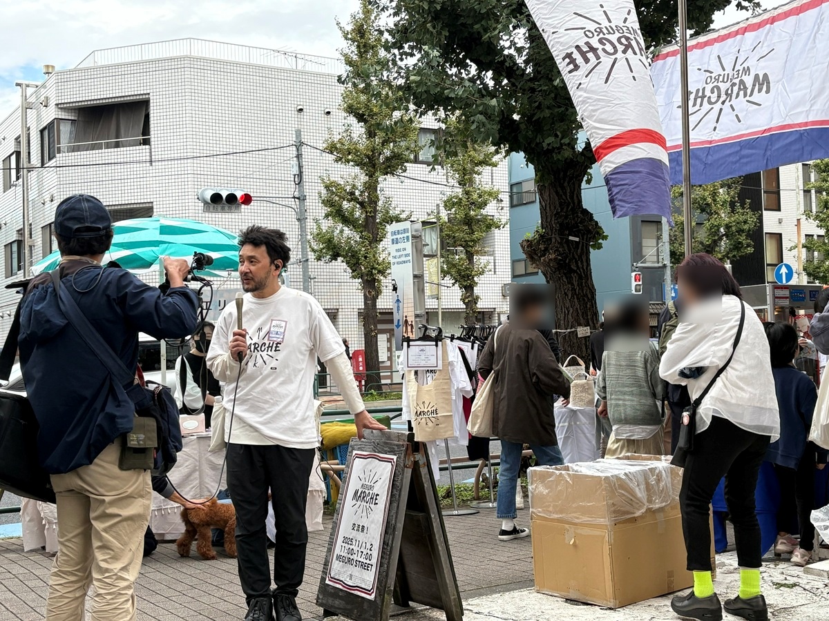 テレビの取材を受ける主宰者のヤマモトタケシさん