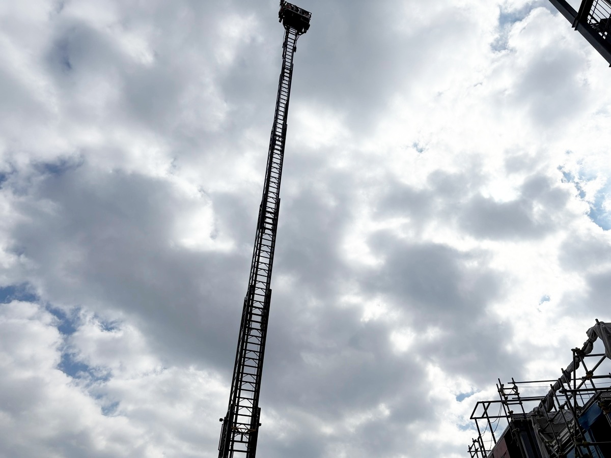 空へと上っていくはしご車のカゴ