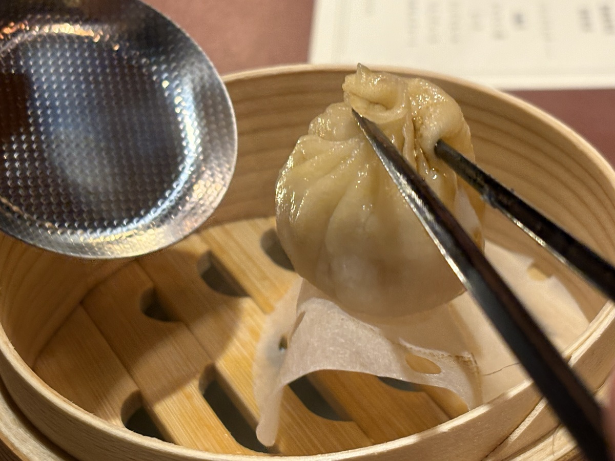 熱々の小籠包をつまみ上げる